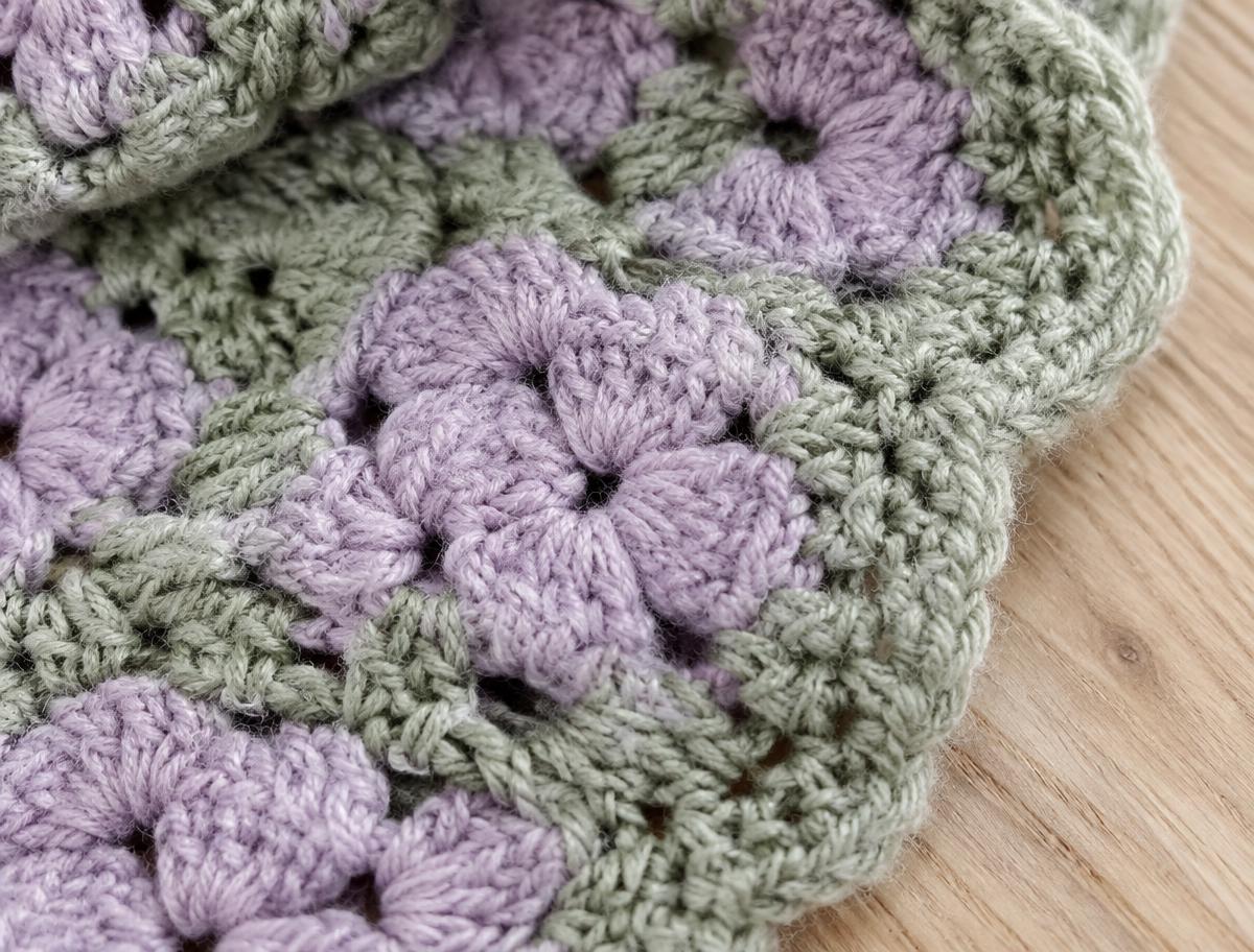 Close-up of lilac and sage handmade crochet stitches.